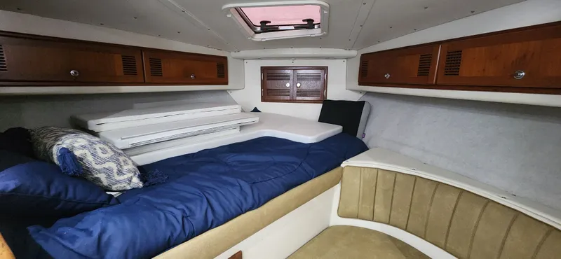 Slide: The Image of Interior cabin of a 1995 Cabo 35 Express boat with cozy bedding and wooden cabinets. - 24