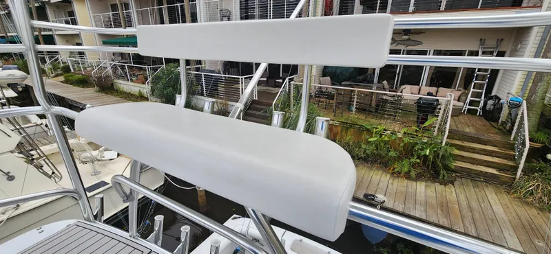 Slide: The Image of 1995 Cabo 35 Express boat with white seating on deck, dockside view. - 54