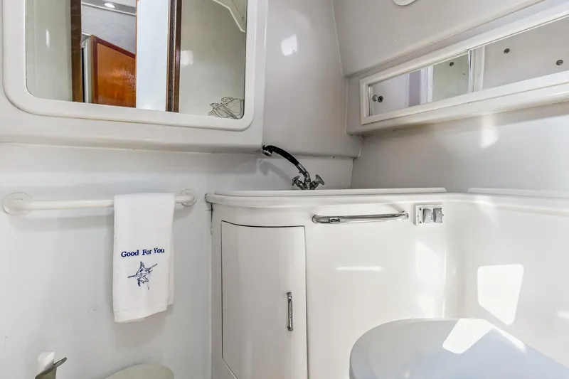 Slide: The Image of Bathroom interior of 1995 Cabo 35 Express yacht, featuring sink, mirror, and towel. - 60