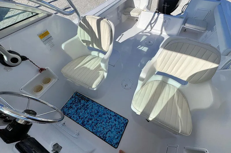 Slide: The Image of 2000 Pro-Line 22 Walkaround boat interior with steering wheel and cushioned seats. - 11