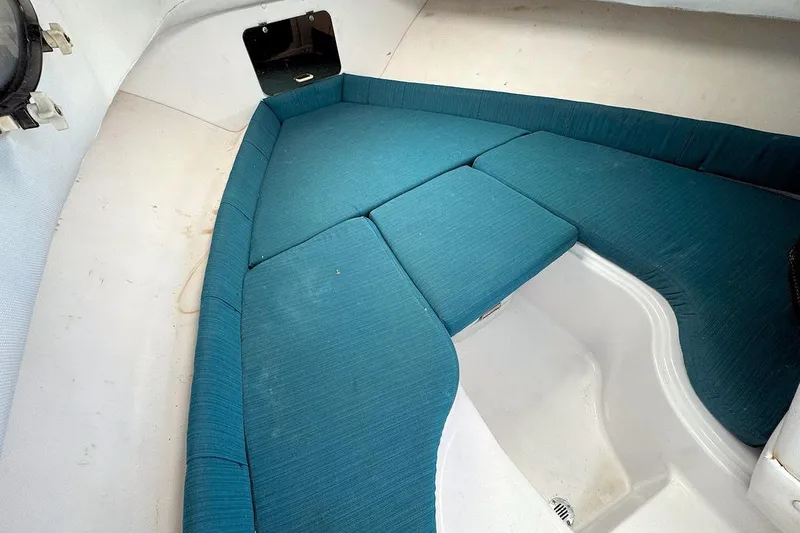 Slide: The Image of 2000 Pro-Line 22 Walkaround cabin interior with teal cushions and white flooring. - 14