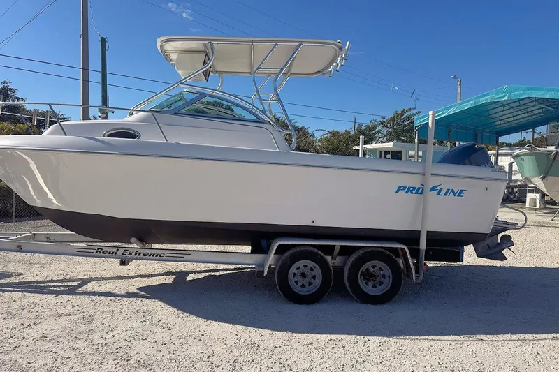 Slide: The Image of 2000 Pro-Line 22 Walkaround boat on trailer, parked outdoors under clear sky. - 4