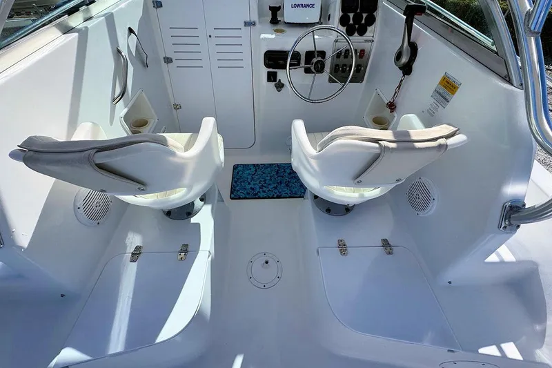 Slide: The Image of 2000 Pro-Line 22 Walkaround boat cockpit with steering wheel and two white seats. - 8