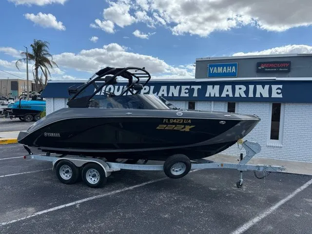 The Image of 2025 Yamaha Boats 222XE on trailer outside marine store. - 1