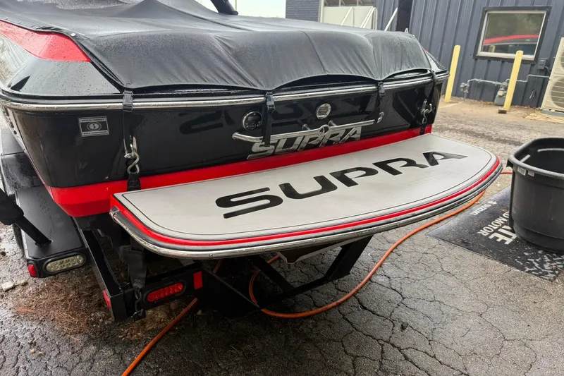 Slide: The Image of 2011 Supra Launch 242 boat with cover, rear view, in a garage setting. - 9