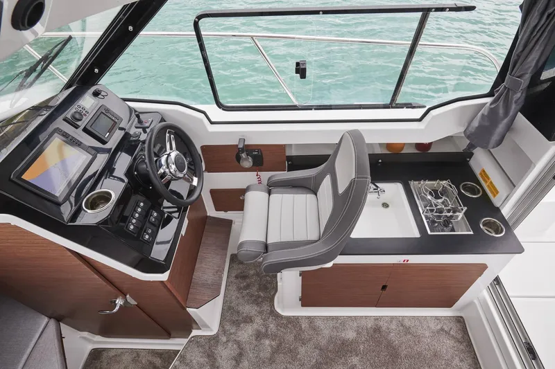 Slide: The Image of Interior of 2026 Jeanneau NC 795 Series 2 boat, featuring helm and kitchenette area. - 16