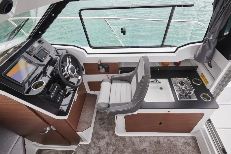 Slide: The Image of Interior of 2026 Jeanneau NC 795 Series 2 boat with helm and kitchenette. - 17