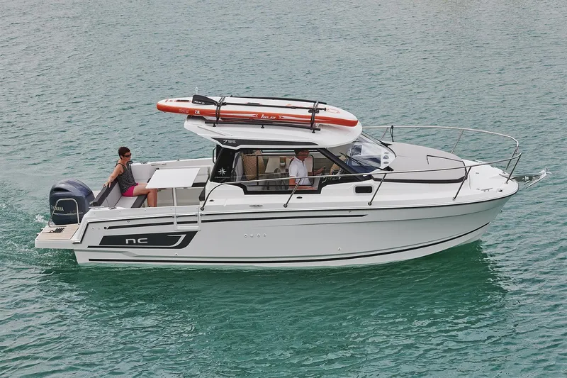 Slide: The Image of 2026 Jeanneau NC 795 Series 2 boat cruising on clear water with passengers onboard. - 27