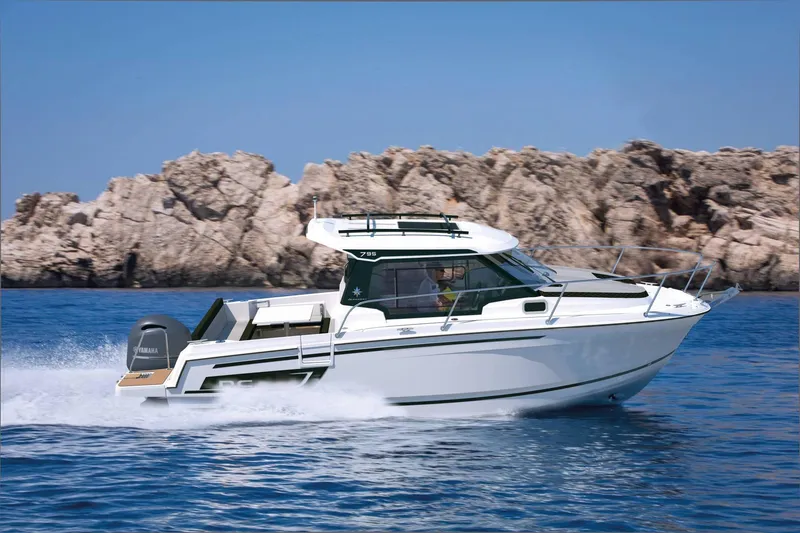 Slide: The Image of 2026 Jeanneau NC 795 Series 2 motorboat cruising near rocky coastline. - 3