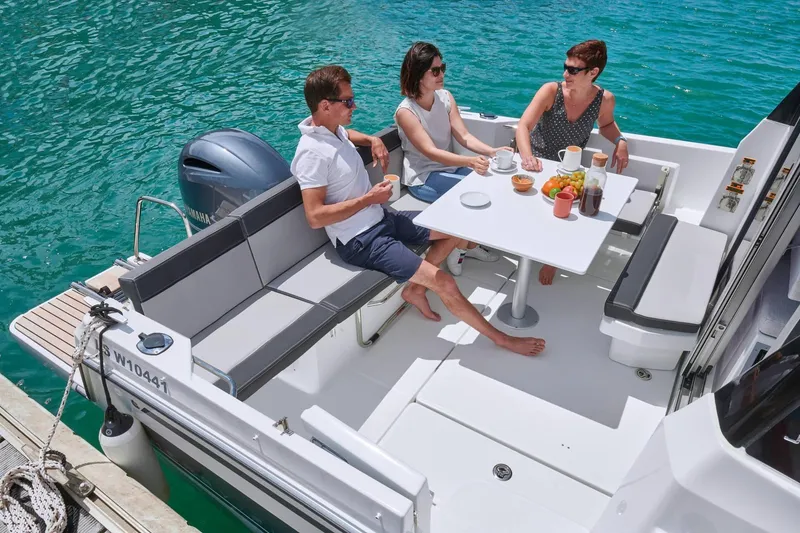 Slide: The Image of People enjoying a meal on a 2026 Jeanneau NC 795 Series 2 boat. - 31