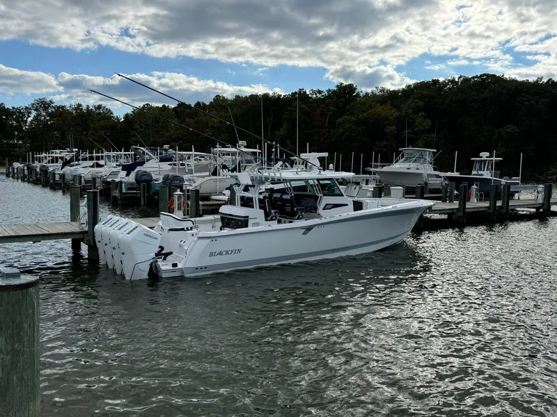 The Image of 2025 Blackfin 400 CC boat docked in a marina, surrounded by other vessels. - 0