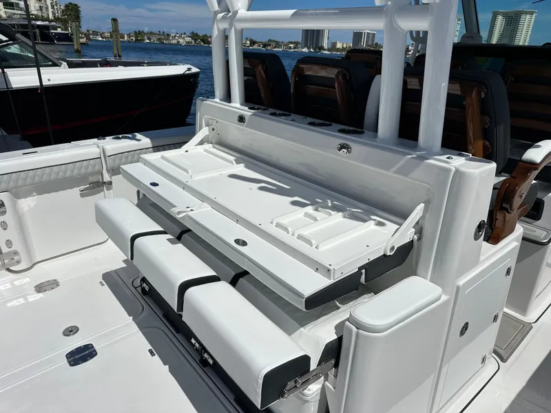 Slide: The Image of 2025 Blackfin 400 CC boat interior with seating and storage, docked by the waterfront. - 15