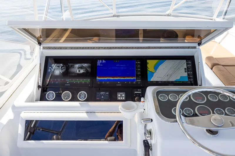 Slide: The Image of Control panel of 1996 Jim Smith 60 Sportfish boat with navigation screens and gauges. - 13