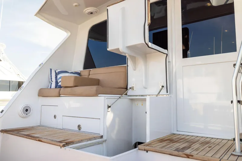 Slide: The Image of 1996 Jim Smith 60 Sportfish yacht with cushioned seating and wooden deck details. - 21