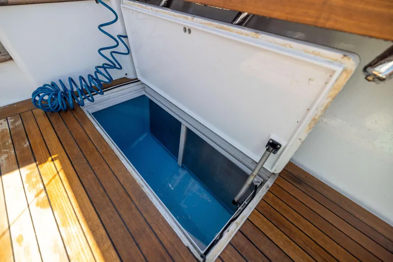 Slide: The Image of Open storage compartment on 1996 Jim Smith 60 Sportfish boat with wooden deck. - 23