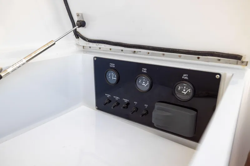 Slide: The Image of Control panel of a 1996 Jim Smith 60 Sportfish boat, featuring fuel and water gauges. - 26