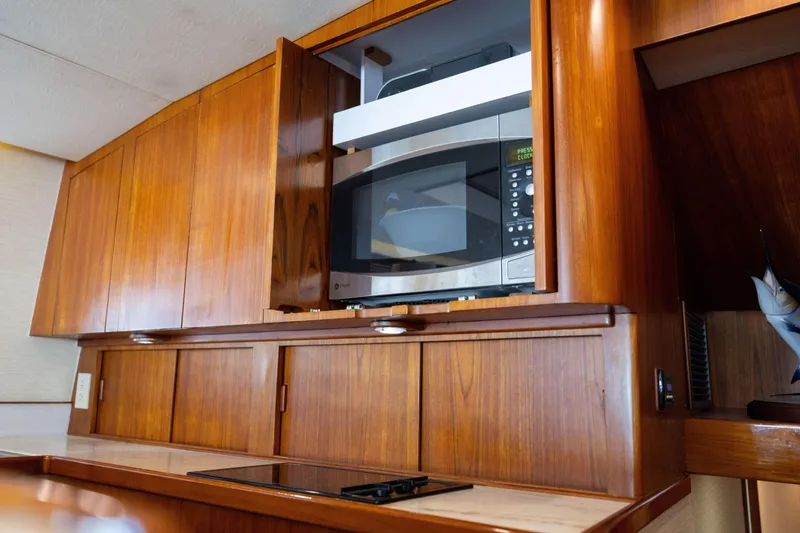 Slide: The Image of Wooden kitchen cabinetry with built-in microwave on a 1996 Jim Smith 60 Sportfish boat. - 29