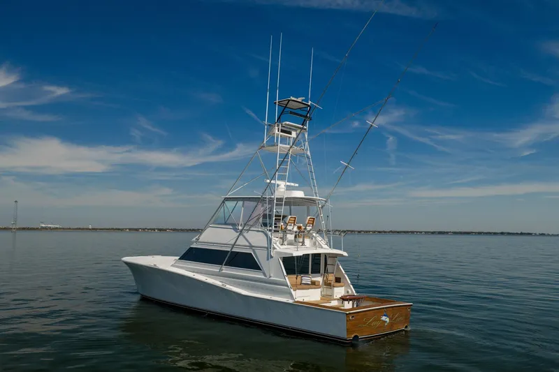 Slide: The Image of 1996 Jim Smith 60 Sportfish yacht on calm water under clear blue sky. - 3