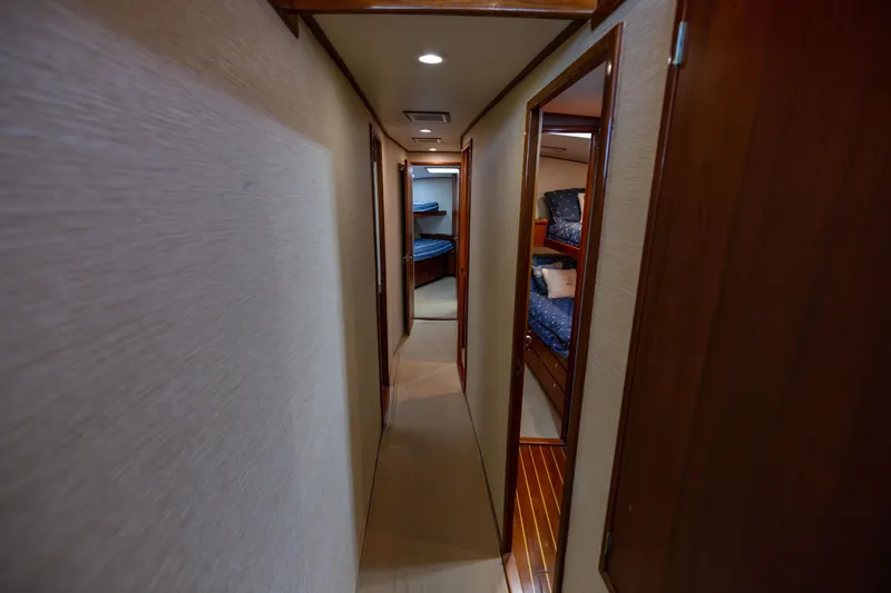 Slide: The Image of Narrow hallway inside 1996 Jim Smith 60 Sportfish yacht with wooden doors and cozy cabins. - 32
