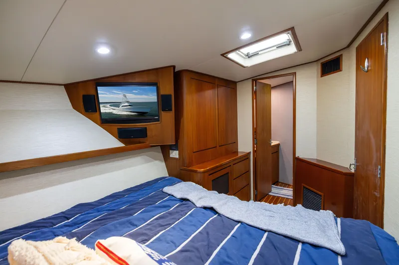 Slide: The Image of Luxurious cabin interior of a 1996 Jim Smith 60 Sportfish yacht, featuring wood paneling and a TV. - 36