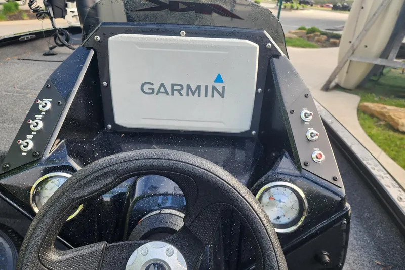 Slide: The Image of 2023 Crestliner XF 179 boat dashboard with Garmin navigation system and control switches. - 2