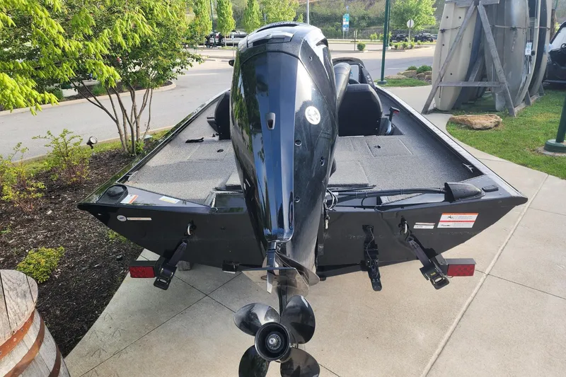Slide: The Image of 2023 Crestliner XF 179 boat with outboard motor, parked on a concrete path. - 3