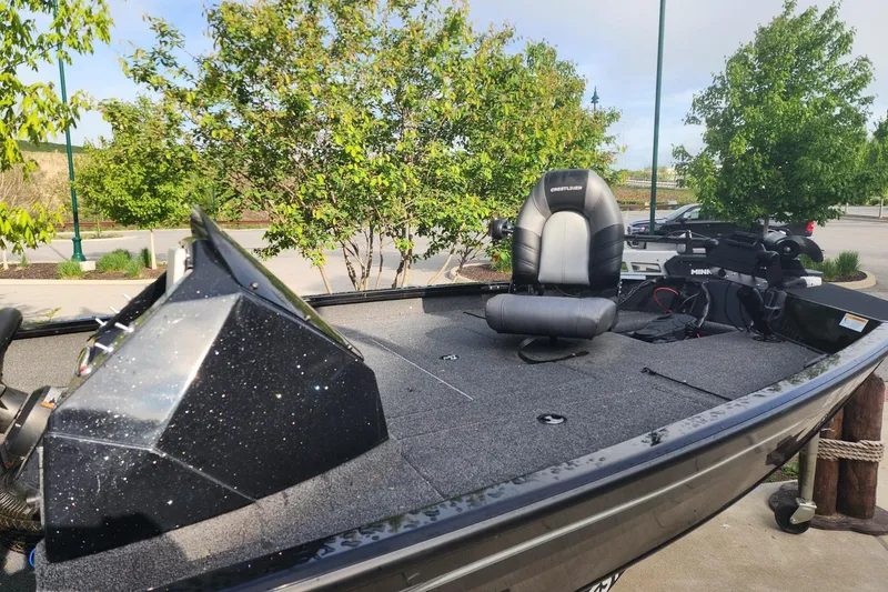 Slide: The Image of 2023 Crestliner XF 179 fishing boat with seating and control panel, parked outdoors. - 4