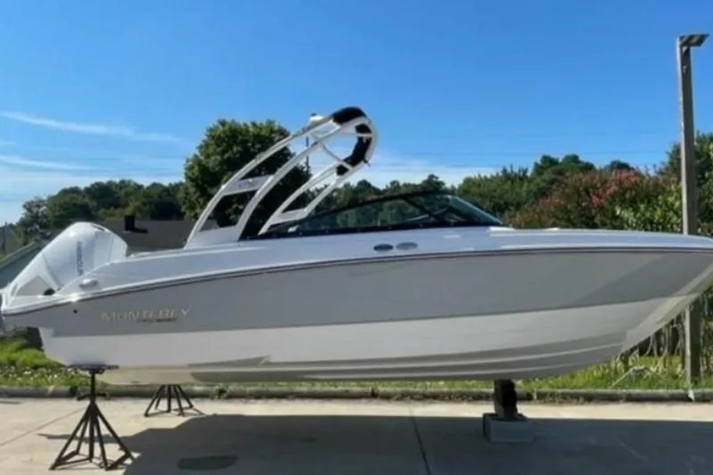 The Image of 2026 Monterey M-225 boat on stands, sleek design, outdoors under blue sky. - 0