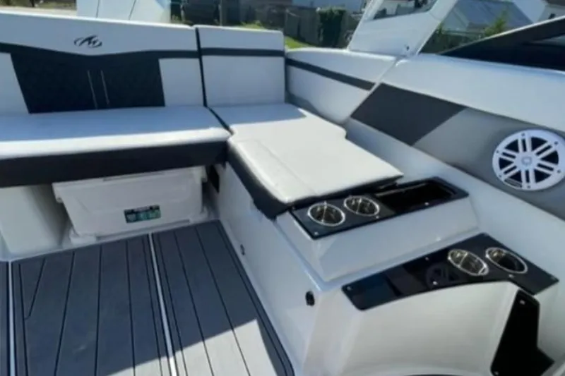 Slide: The Image of 2026 Monterey M-225 boat interior with cushioned seating and cup holders. - 3