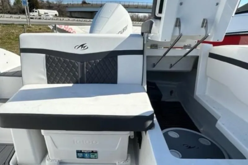 Slide: The Image of 2026 Monterey M-225 boat interior with cushioned seating and storage compartment. - 4