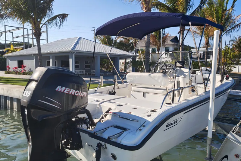 Slide: The Image of 2006 Boston Whaler 180 Dauntless boat docked, featuring a Mercury 135 outboard motor. - 11