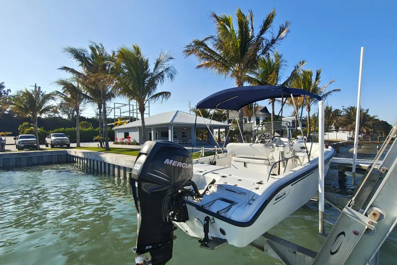 Slide: The Image of 2006 Boston Whaler 180 Dauntless boat docked, featuring a Mercury outboard motor. - 13