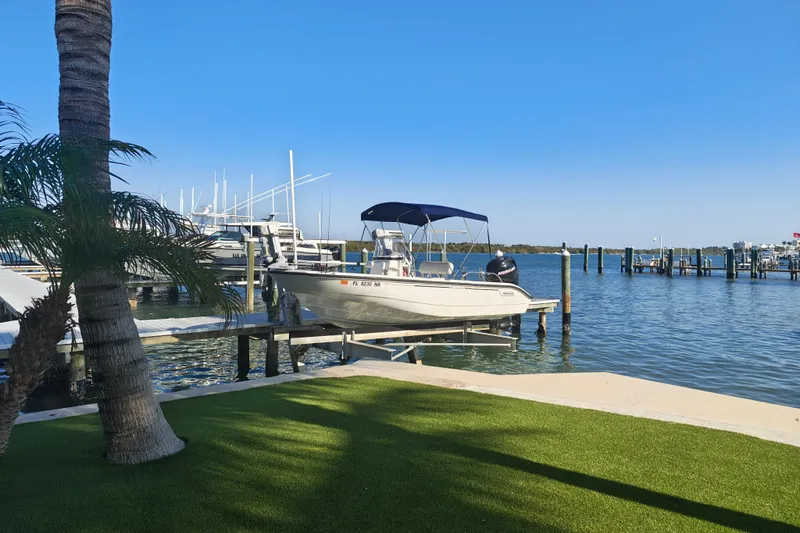 Slide: The Image of 2006 Boston Whaler 180 Dauntless docked by a scenic marina with palm trees. - 8