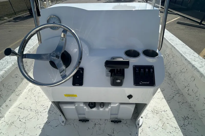 Slide: The Image of 2026 Coastal Skiff 212 boat console with steering wheel and controls. - 10