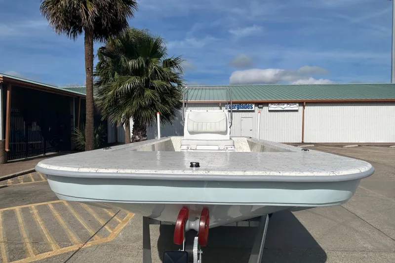 Slide: The Image of 2026 Coastal Skiff 212 boat on trailer, parked outdoors near palm trees. - 3