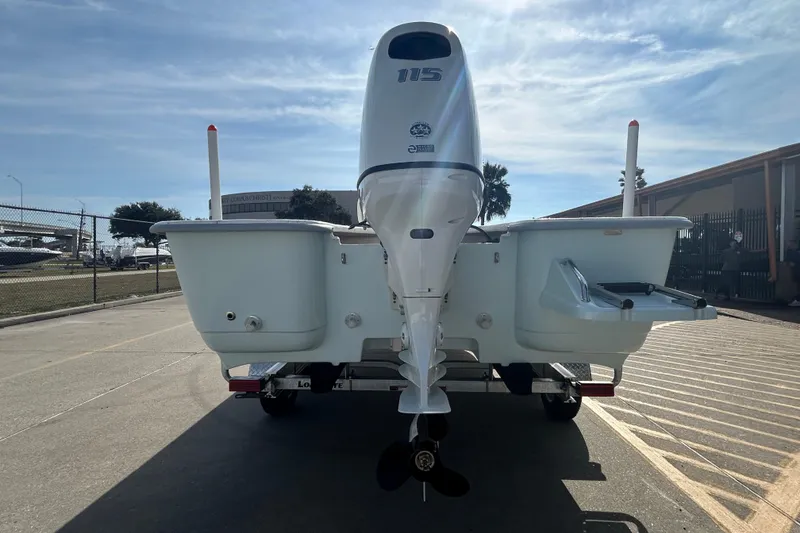 Slide: The Image of 2026 Coastal Skiff 212 boat with outboard motor on trailer, parked outdoors. - 7