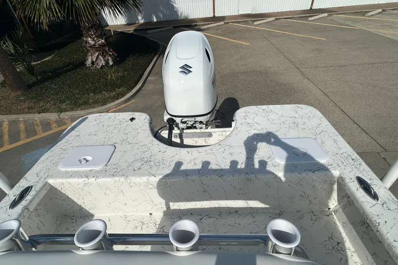 Slide: The Image of 2026 Coastal Skiff 212 boat with Suzuki outboard motor in a parking lot. - 8