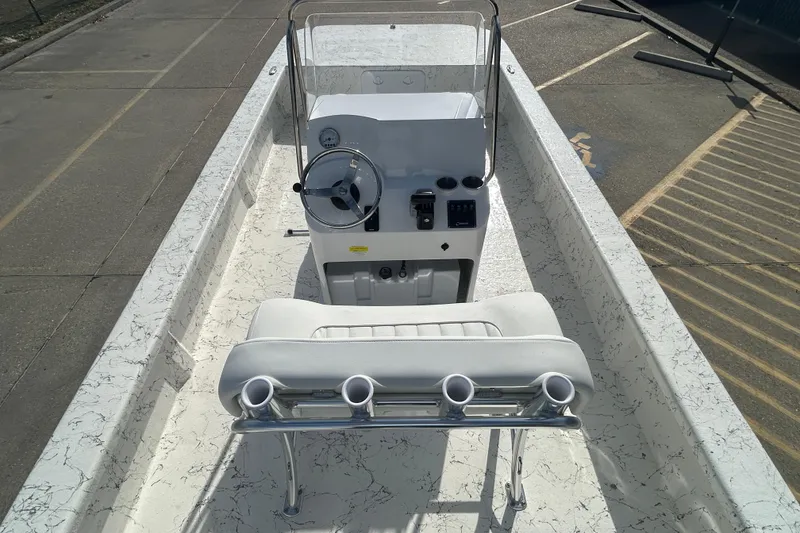 Slide: The Image of 2026 Coastal Skiff 212 boat interior with console and seating, featuring rod holders. - 9