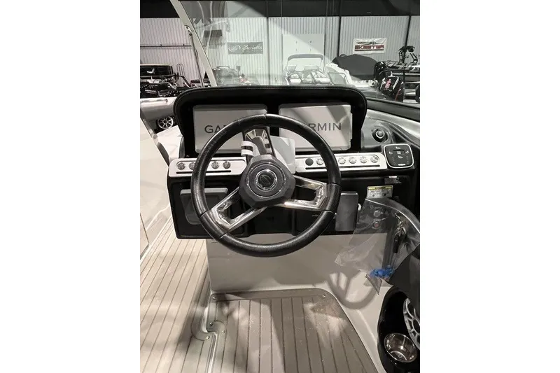 Slide: The Image of 2026 Crownline 298 SS boat helm with Garmin navigation system and modern steering wheel. - 10