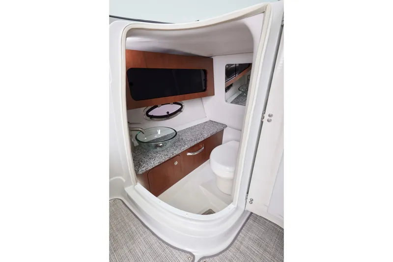 Slide: The Image of 2026 Crownline 298 SS boat interior bathroom with modern sink and granite countertop. - 12