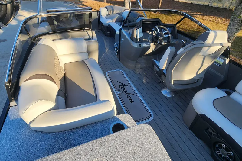 Slide: The Image of 2023 Avalon Excalibur 25' boat interior with luxurious seating and modern dashboard. - 12