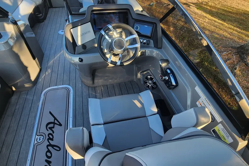 Slide: The Image of 2023 Avalon Excalibur 25' boat interior with modern steering and control panel. - 13