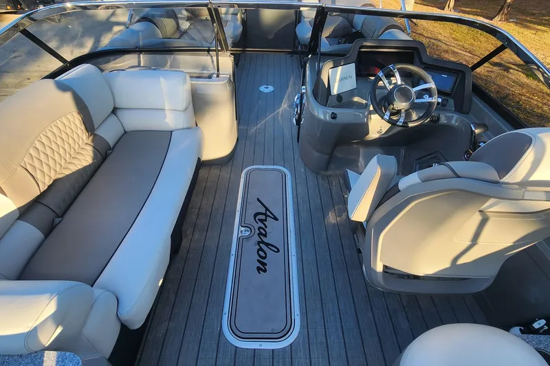 Slide: The Image of 2023 Avalon Excalibur 25' boat interior with luxurious seating and modern dashboard. - 15