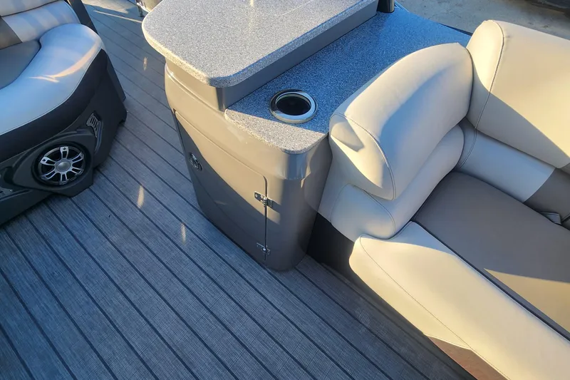 Slide: The Image of Luxurious seating and console on 2023 Avalon Excalibur 25' boat, featuring cup holder and speaker. - 21