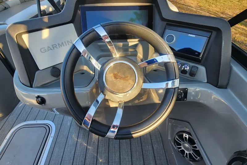 Slide: The Image of Steering wheel of 2023 Avalon Excalibur 25' boat with Garmin and Fusion displays. - 23