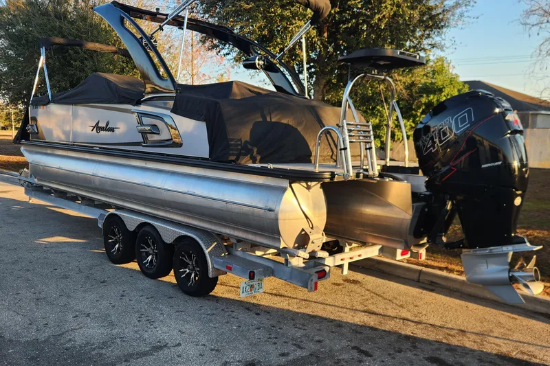 Slide: The Image of 2023 Avalon Excalibur 25' pontoon boat on trailer with powerful outboard motor. - 6