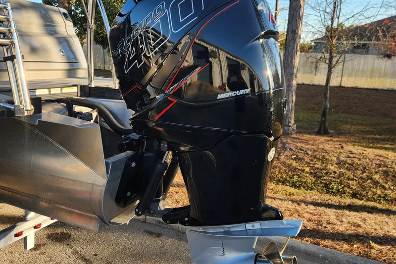 Slide: The Image of 2023 Avalon Excalibur 25' with Mercury Racing 400 outboard engine, parked outdoors. - 7