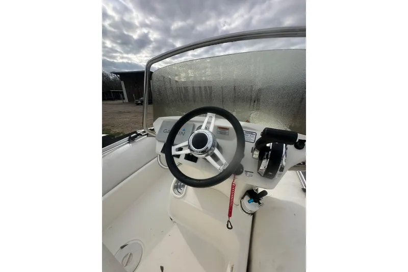 Slide: The Image of 2023 Zodiac N-ZO 680 boat cockpit with steering wheel and controls, under cloudy sky. - 10