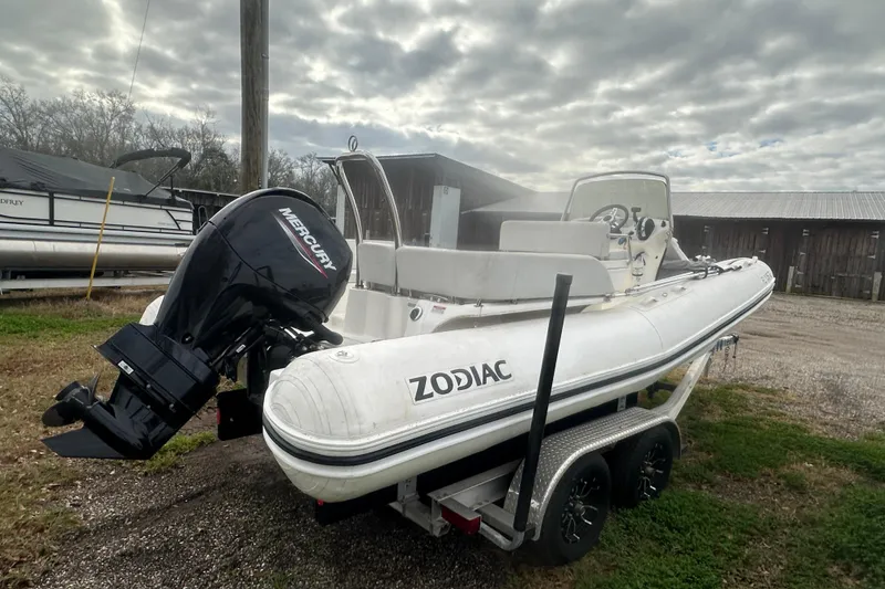 Slide: The Image of 2023 Zodiac N-ZO 680 boat on trailer with Mercury outboard motor, cloudy sky background. - 8