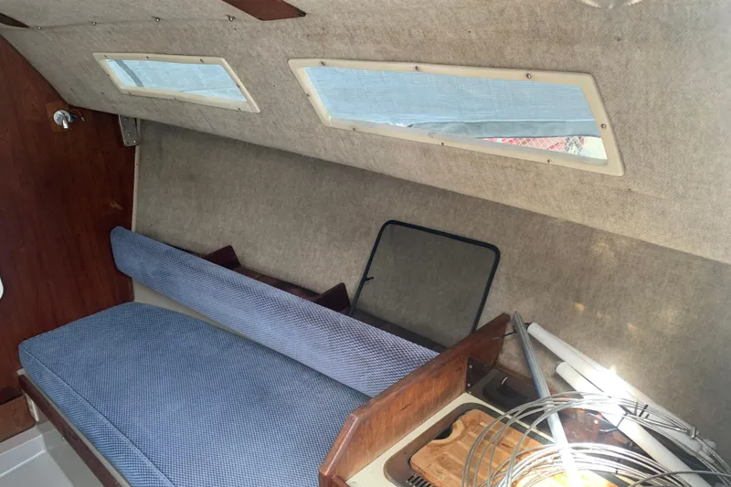 Slide: The Image of Interior of a 1985 Oday 272 sailboat with blue seating and wooden accents. - 15